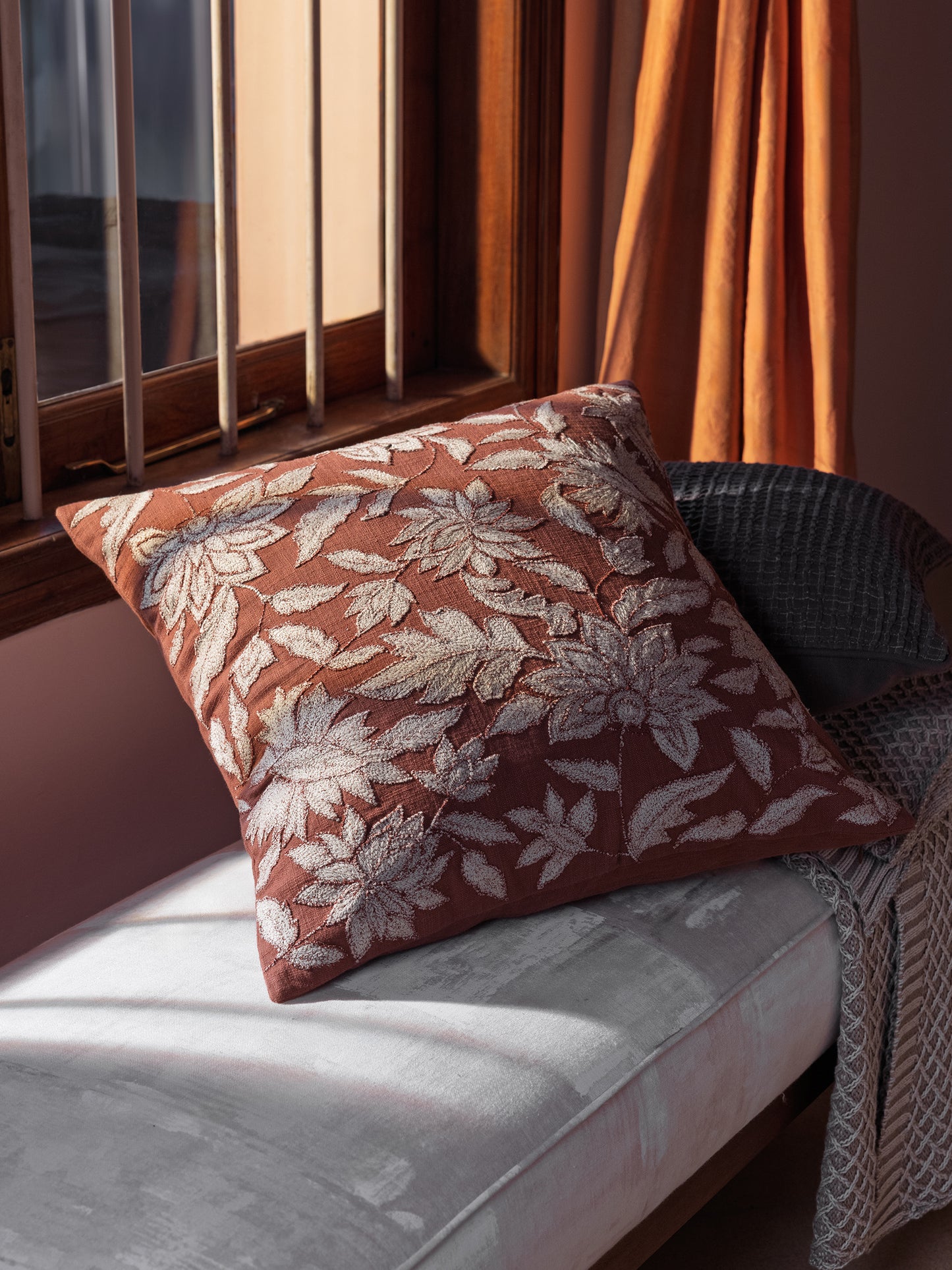 Warm rust decorative pillow styled on sofa