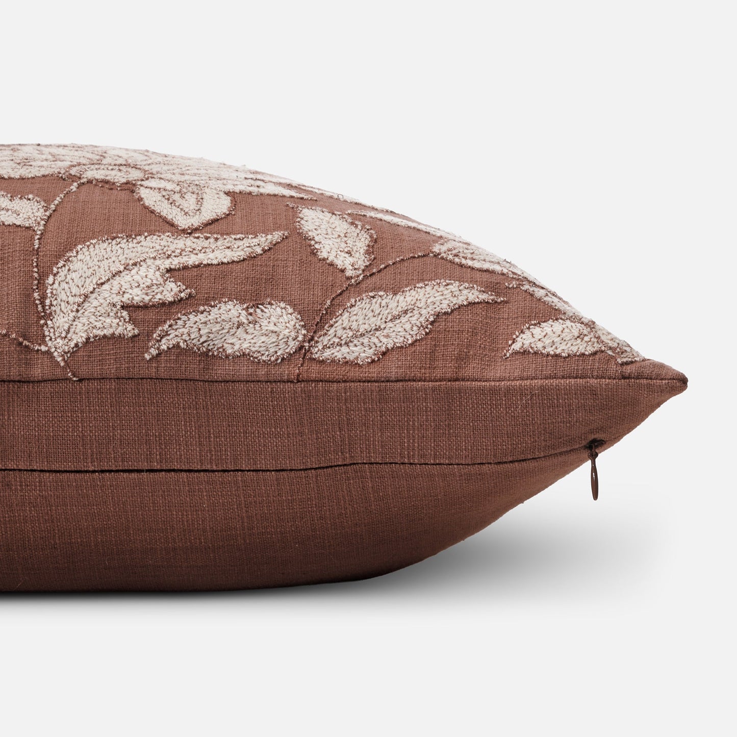 Embroidered rust cushion with textured surface